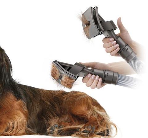 Dog being groomed with vacuum brush attachment set