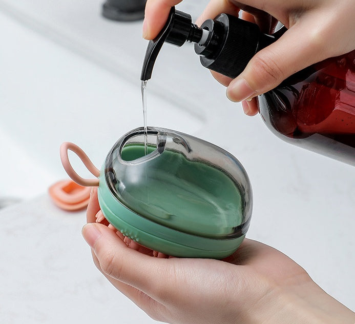 Silicone cat bath brush releasing shampoo while scrubbing